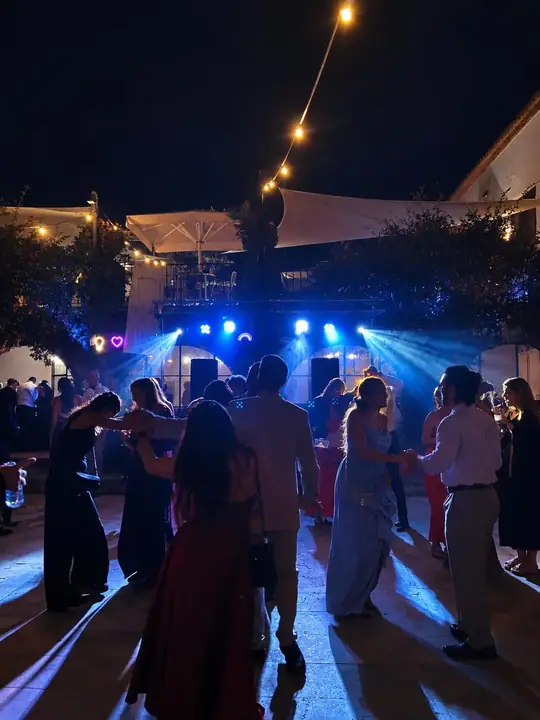 Invitados bailando en una boda con iluminación profesional