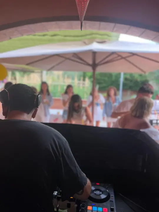 DJ pinchando en una celebración al aire libre con globos