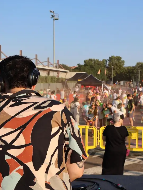 DJ animando un evento popular al aire libre con mucha gente